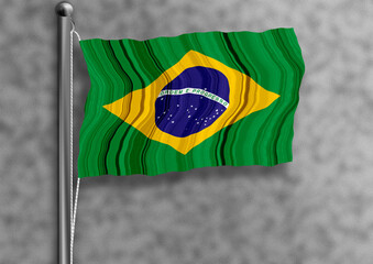 Brazilian flag flying on a flagpole, isolated, textured wall in the background.
