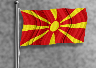North Macedonia flag flying on a flagpole, isolated, textured wall in the background.