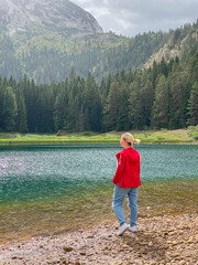 Woman in red windbreaker near the Black Lake in the Durmitor national park