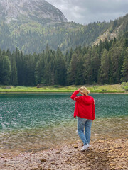 Woman in red windbreaker near the Black Lake in the Durmitor national park