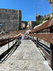Middle-aged woman relaxing at amphitheater of Kanli Kula Fortress
