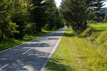 vista panoramica su parte della lunga pista ciclabile Alpeadria, a fondovalle, in mezzo alle montagne, nel Friuli Venezia Giulia nord-orientale, di giorno, con cielo sereno, in estate