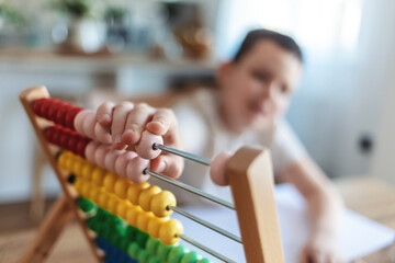 Student, writing and learning boy with dad teacher help with math problem homework solution together in living room. Happy homeschool class dad or father teaching kid abacus and numbers education.