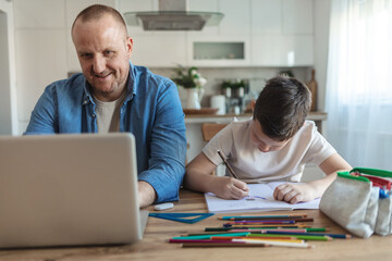 Naklejka premium Businessman working at home with child. Child is making homework. Father and school-boy working form home.