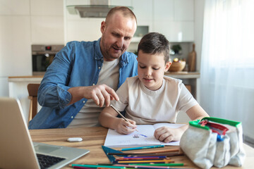 Businessman working at home with child. Child is making homework. Father and school-boy working...