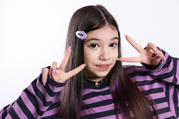 Fototapeta premium Teenage girl in stylish clothes and accessories showing V-sign on white background. Makeup in anime style