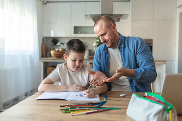 Angry father yell at his son to do homework as soon as possible. xhausted father help son to finish his homework while son have attention deficit disorder and dont want to study anymore.