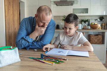 Angry father yell at his son to do homework as soon as possible. xhausted father help son to finish his homework while son have attention deficit disorder and dont want to study anymore.