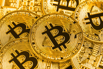 background of Many golden bitcoins are laying on a surface, creating a visually appealing representation of cryptocurrency, wealth, and the future of finance