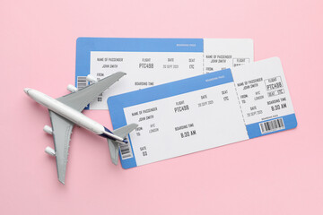 Travel agency. Flight tickets and plane model on pink background, flat lay
