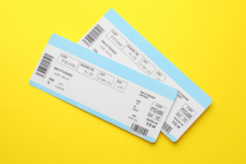 Travel agency. Flight tickets on yellow background, top view