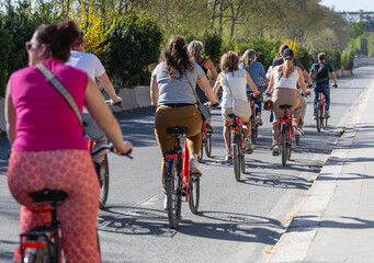 Obraz premium Un groupe de personnes en train de faire du vélo à Paris, sur une piste cyclable. Le format de l'image est horizontal.