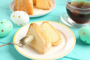 Pieces of delicious bundt cake, Easter eggs and tea on light blue wooden table, closeup