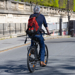 Un homme en train de faire du v&eacute;lo &agrave; Paris, sur une piste cyclable. Le format de l'image est carr&eacute;.