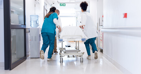 Gurney, healthcare and rushing with doctors in hospital for emergency, operation or surgery. Medical, running and urgency with team of medicine professionals in hallway to save patient or victim