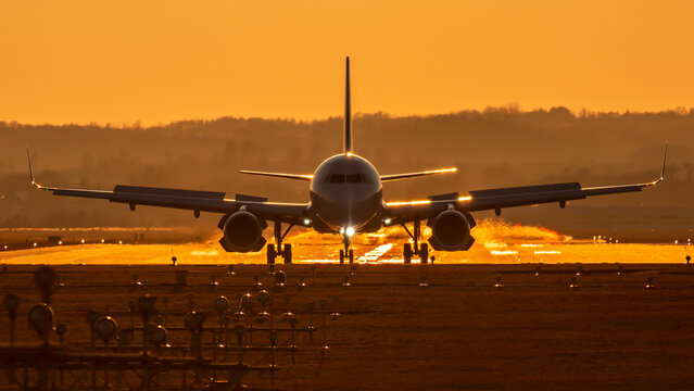 An aircraft after landing at international airport with opened reverse thrust during airplane lannding roll