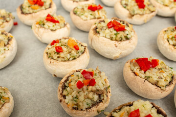 Stuffed champignon mushrooms with rice, parsley and pepper on a sheet of baking paper