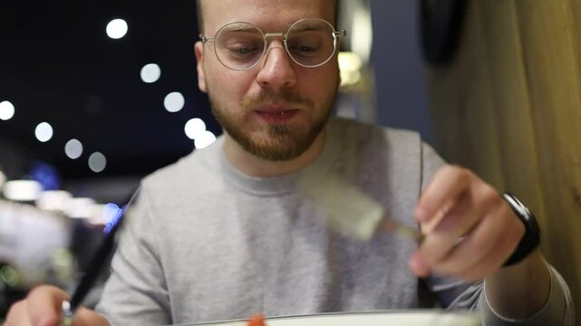 man eating salad with fork and knife