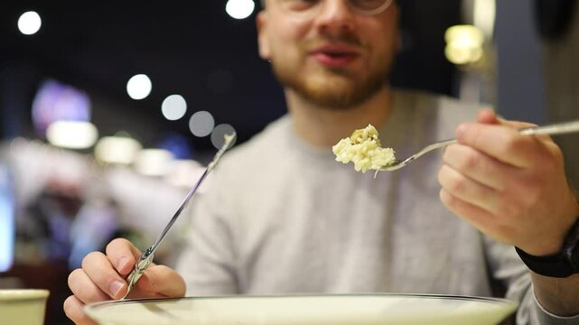 man eating salad with fork and knife
