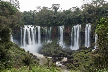 Fototapeta premium Majestic Waterfall Cascading Down Lush Green Cliffs