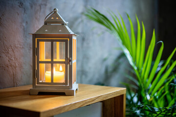 Serene Candlelight Illuminated Lantern on Wooden Table with Greenery