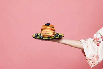 Close up cropped female housewife housekeeper hold in hand empty plate with pancakes isolated on...