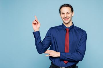 Young happy rich employee business man corporate lawyer in classic formal shirt red tie work in office point index finger aside on area isolated on plain pastel light blue background studio portrait