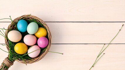 Colorful easter eggs in a basket on a white wooden background