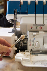 the foreman dusts off the overlock sewing machine