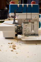 the foreman dusts off the overlock sewing machine