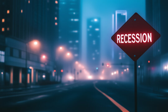 Red recession warning road sign on empty city street at night with fog and skyscrapers, concept for economic crisis, downturn, and financial uncertainty
