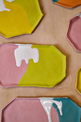 top view of handmade clay plates covered with colored glazes, ready for firing