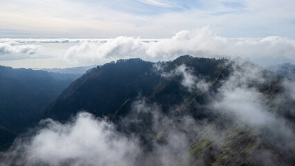 Majestic clouds dance over a serene mountain range at dawn, revealing nature's breathtaking beauty in the morning light