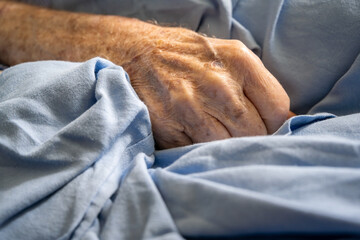 Closeup of hand of elderly man in hospital bed