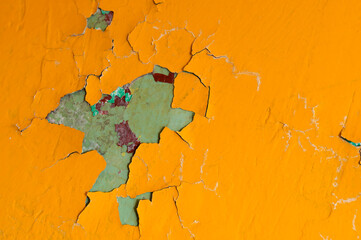 Peeling paint of orange color on the concrete wall, peeling paint texture background
