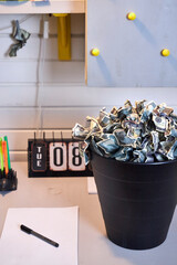 on the desk in the office is a garbage can of crumpled money dollars, the concept of inflation