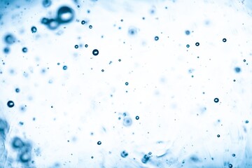 Abstract underwater scene with soft blue bubbles suspended in bright light fluid background creating minimal dreamy texture.