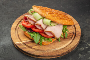 sandwich with pork ham, cheese and salad on a wooden board, top view. copy space