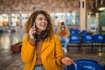 Fototapeta premium happy adult curly hair woman talk on mobile phone on train station