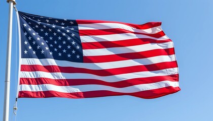 Obraz premium American flag waving proudly against a clear blue sky - patriotic symbol