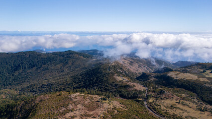 Breathtaking view of rolling mountains and clouds captured in a serene landscape during a clear day