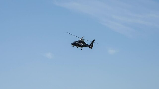 close-up of an SAS Special Air Service Army Air Corps Dauphin helicopter flying low overhead in blue sky