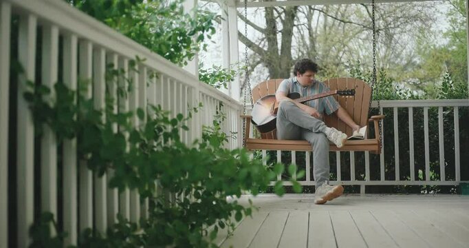 Close up of hands strumming and playing the acoustic guitar 