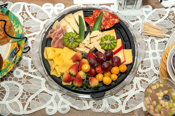 Gourmet Cheese and Cold Cuts Board. Various types of cheese served on a wooden table.