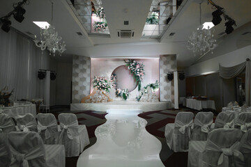 Modern wedding decor with large abstract floral arrangements in soft pastel colors.