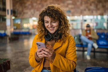 woman tourist use mobile phone for research and fun on train station