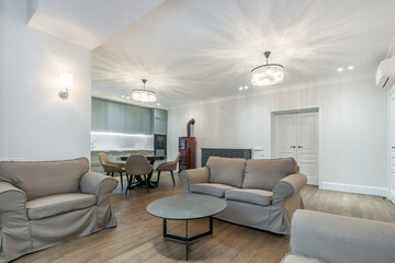 Exclusive interior design of the studio apartment, decorated in pastel colors. Stylish furniture, beautiful chandeliers, autonomous stove.