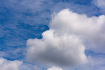 Obraz premium White cumulus clouds in a bright blue sky 