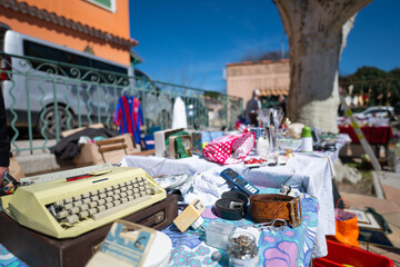 Knick-knacks, trinkets, gadgets, ornaments and vintage items for sale on a table at a yard sale on a beautiful sunny day.