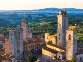 Obraz premium Aerial view of San Gimignano medieval town towers skyline and countryside landscape on sunrise. Tuscany, Italy.